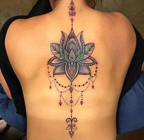 Tatuaje de flor de loto morada en mujer (espalda)