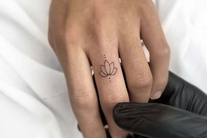 Tatuaje de la flor de loto en dedo