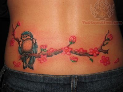 Owl on branch of flowers tattoo on lower back