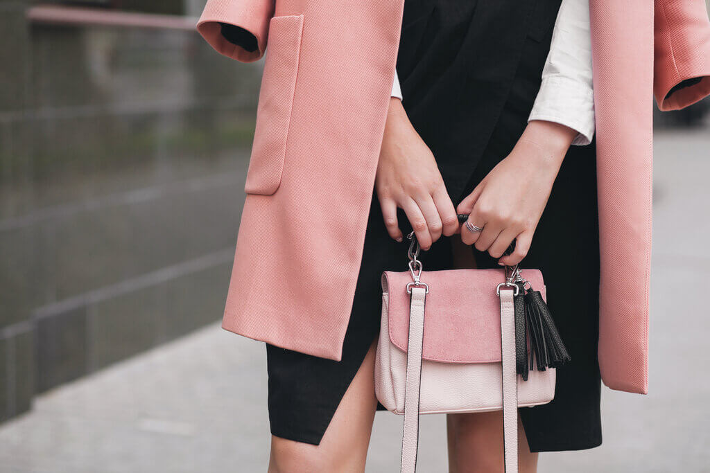 mujer sosteniendo un bolso rosa