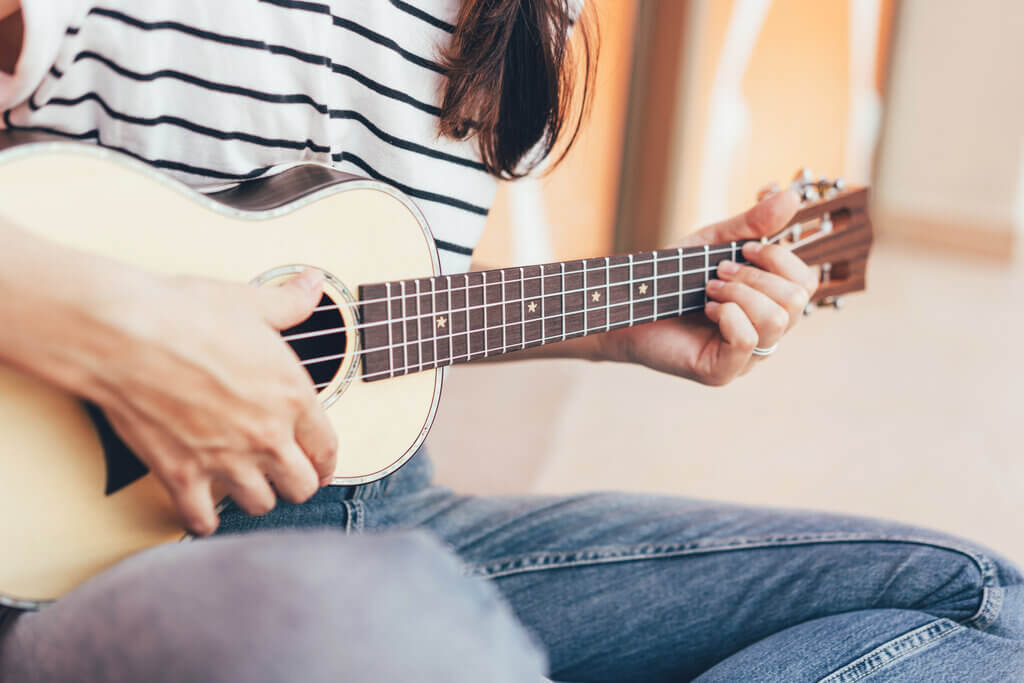 mujer tocando una canción en el ukelele