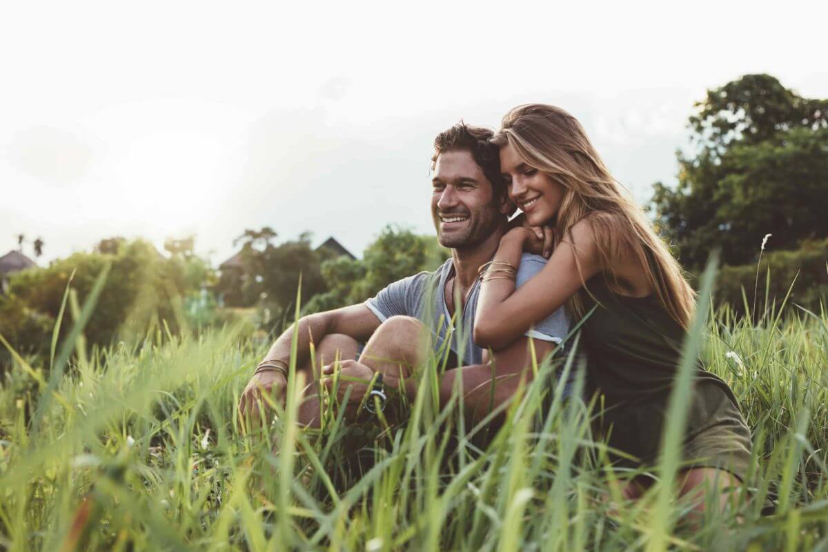 pareja joven abrazándose en un campo de hierba